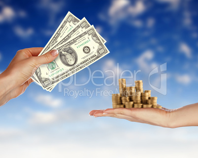 Human hands holding money against blue sky