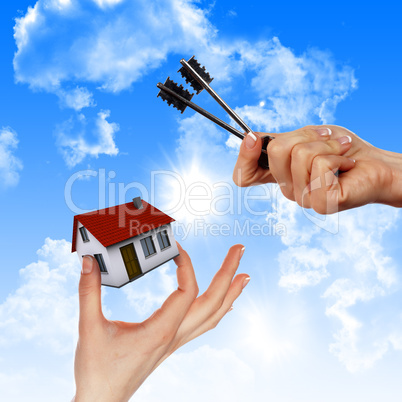 House in the hands against the blue sky
