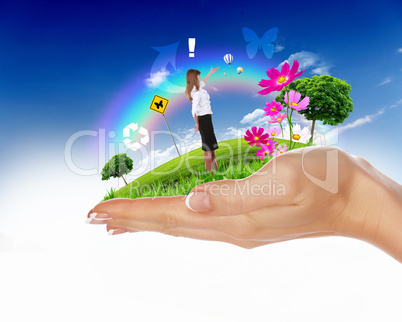 Human hand holding a green landscape