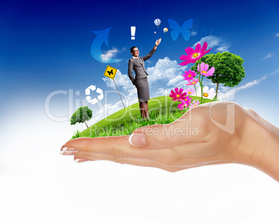 Human hand holding a green landscape