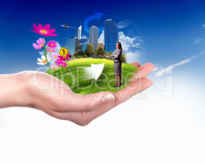 Human hand holding a green landscape