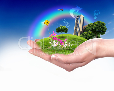 Human hand holding a green landscape