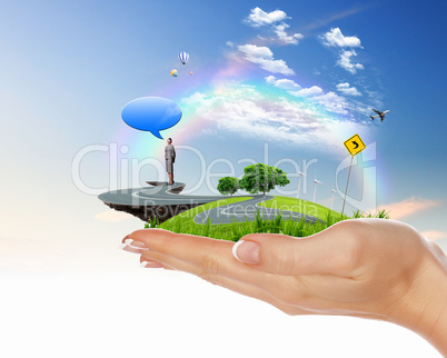 Human hand holding a green landscape