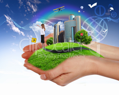 Human hand holding a green landscape