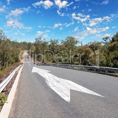 Empty countryside road with white arrow