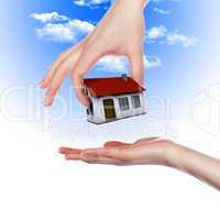 House in the hands against the blue sky