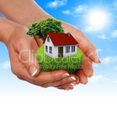 House in the hands against the blue sky