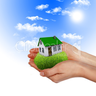 House in the hands against the blue sky