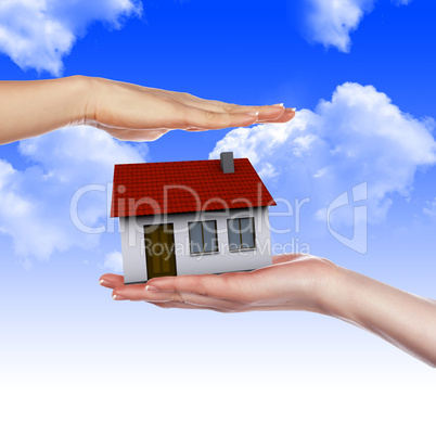 House in the hands against the blue sky