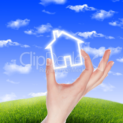 House in the hands against the blue sky