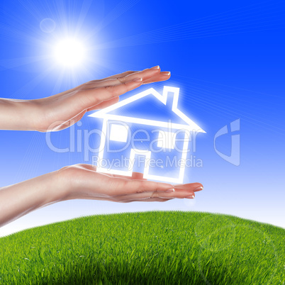 House in the hands against the blue sky