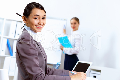Young women in business wear working in office