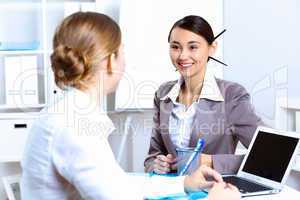 Young women in business wear working in office