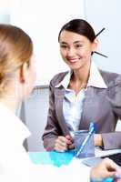 Young women in business wear working in office