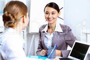 Young women in business wear working in office