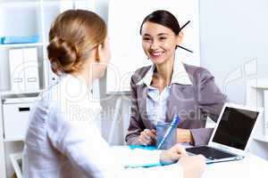 Young women in business wear working in office