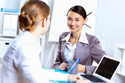 Young women in business wear working in office