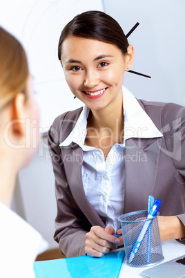 Young women in business wear working in office