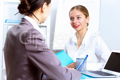 Young women in business wear working in office