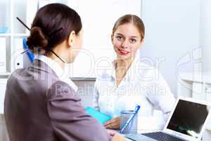 Young women in business wear working in office