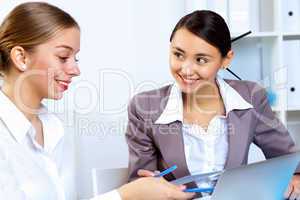 Young women in business wear working in office