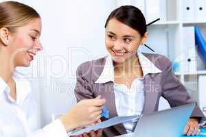 Young women in business wear working in office