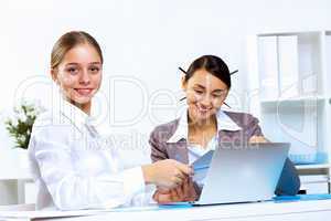 Young women in business wear working in office