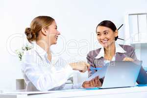 Young women in business wear working in office