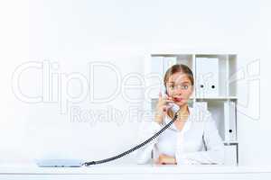 Young woman with a phone in office