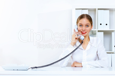 Young woman with a phone in office