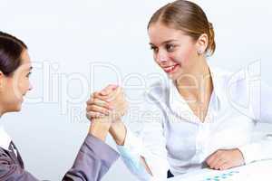 Young women arm wrestling in office