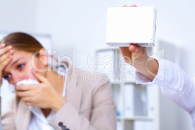 Woman in office holding a pack of medicine