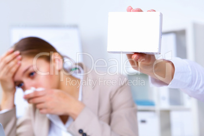 Woman in office holding a pack of medicine