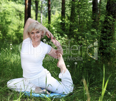 An elderly woman practices yoga