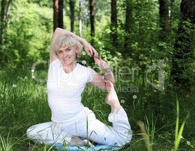 An elderly woman practices yoga
