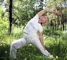 An elderly woman practices yoga