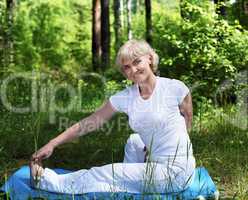 An elderly woman practices yoga