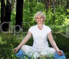 An elderly woman practices yoga