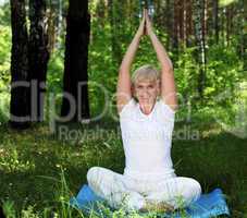 An elderly woman practices yoga