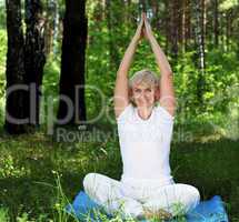 An elderly woman practices yoga