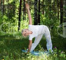 An elderly woman practices yoga