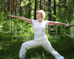 An elderly woman practices yoga