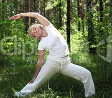 An elderly woman practices yoga