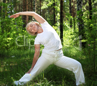 An elderly woman practices yoga