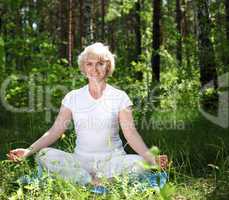 An elderly woman practices yoga