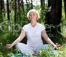 An elderly woman practices yoga