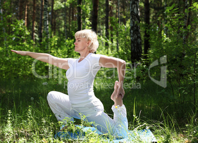 An elderly woman practices yoga