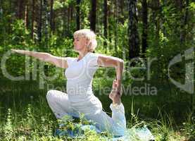 An elderly woman practices yoga