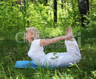 An elderly woman practices yoga