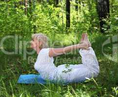 An elderly woman practices yoga